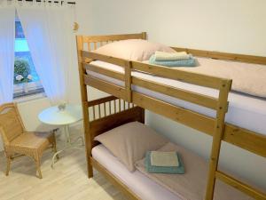 - deux lits superposés dans une chambre avec une table dans l'établissement Ferienwohnung am Hörnle, à Königsfeld im Schwarzwald