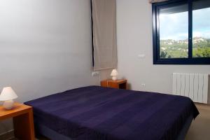 a bedroom with a blue bed and a window at VISTA MAR - MEGIN in Tamariu +9 photos