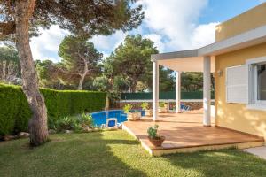 a backyard with a wooden deck and a swimming pool at Villa Moll Moll in Cala Blanca