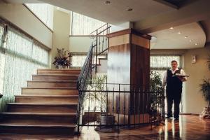 a woman standing next to a staircase in a building at Denisa Boutique in Poiana Brasov