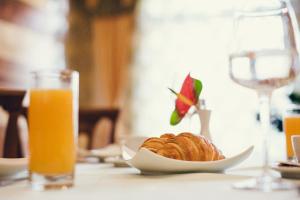 a table with a plate of food and a glass of orange juice at Denisa Boutique in Poiana Brasov