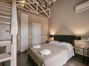 a bedroom with a bed with two towels on it at Varaba Country House in Markopoulo