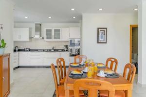 a dining room with a table and chairs and a kitchen at Boavista in Calheta