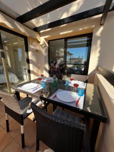 een eettafel met een glas wijn op een balkon bij Magnifique appartement dans Roda Golf (phase 4) in San Javier