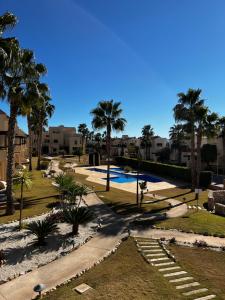 un complejo con piscina y palmeras en Magnifique appartement dans Roda Golf (phase 4), en San Javier