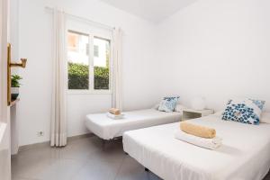 a white room with two beds and a window at Villa Moll Moll by Escape Home in Cala Blanca +15 photos