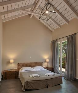 ein Schlafzimmer mit einem großen Bett und einem großen Fenster in der Unterkunft Varaba Country House in Markopoulo