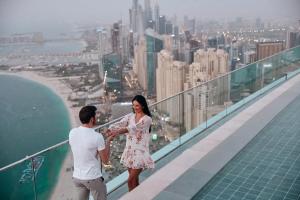 a man and a woman standing on the ledge of a building at Westminster JBR in Dubai