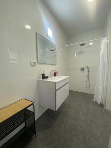 a white bathroom with a sink and a mirror at אירוח אריאל in HaGoshrim