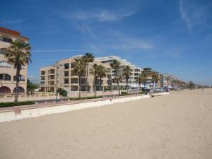 uma linha de edifícios numa praia com palmeiras em Los Monegros em Peñíscola