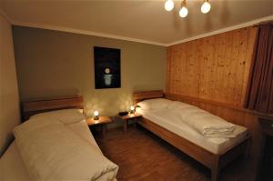 a bedroom with two beds and two candles on tables at Hotel Pension Im Dorf in Zuzwil