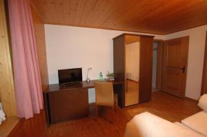 um quarto com uma secretária, um computador e uma cama em Hotel Pension Im Dorf em Zuzwil