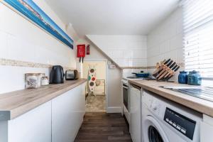 uma cozinha com um balcão e uma máquina de lavar e secar roupa em The Coastal Loft em Bournemouth