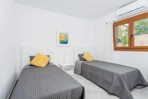 ポリェンサにあるCa'n Salas Granの白い部屋のベッド2台 黄色い枕付