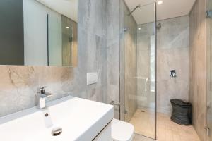 y baño con lavabo blanco y ducha. en Always-Power Trendy De Waterkant Loft en Ciudad del Cabo