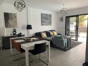 salon z kanapą, stołem i krzesłami w obiekcie Modern villa with sea views w Costa Teguise