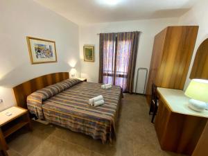 Habitación de hotel con cama y ventana en Guest House by Sos Flores, en Tortolì