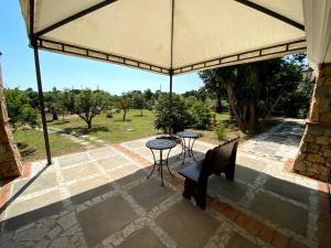 patio con tavolo e sedie sotto un grande ombrellone di Guest House by Sos Flores a Tortolì