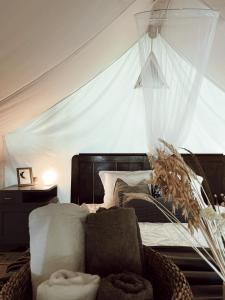 a bedroom with a bed and a chair and a window at Vintage tent at the Lovsin Estate in Metlika