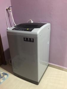 a washing machine sitting on the floor next to a wall at afza homestay Bonda Bukit Besi in Kampong Kuala Talam