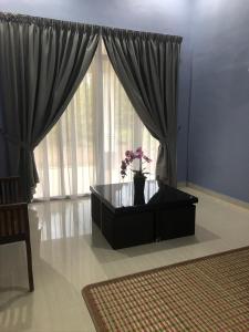 a living room with a coffee table and a window at afza homestay Bonda Bukit Besi in Kampong Kuala Talam