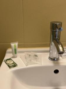 a bathroom sink with a soap dispenser next to it at Suites & Apartments - DP Setubal in Setúbal