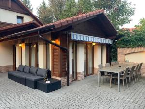 patio z kanapą, stołem i krzesłami w obiekcie Holiday Home Siraly w Miskolc-Tapolca