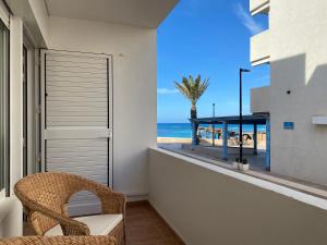 a balcony with a chair and a view of the beach at MARINE APARTMENT in Es Pujols