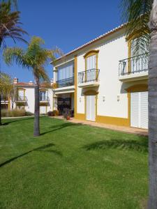 una vista exterior de una casa con palmeras en Carvoeiro, 2BR Pestana Gramacho Golf Apartment, en Estômbar