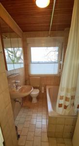 a bathroom with a tub and a toilet and a sink at C. Wulf Gästezimmer in Bückeburg