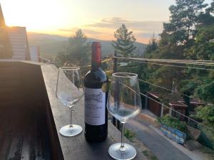 a bottle of wine and two wine glasses on a table at Holiday Home Siraly in Miskolctapolca