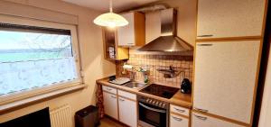 a kitchen with a stove and a sink and a window at C. Wulf Gästezimmer in Bückeburg