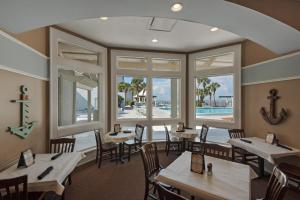 a restaurant with tables and chairs and windows at Bayside Inn 6682 in Destin