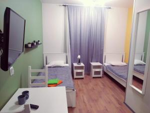 Cette petite chambre comprend deux lits et un bureau. dans l'établissement Krona Hotel, à Dibuny