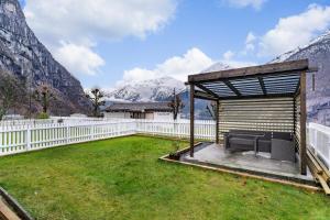 a gazebo in a yard with mountains at Trolltunga Living in Tysso