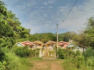 una fila de casas en un pueblo con árboles en Villa Manary, en Itamaracá