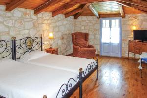 a bedroom with a bed and a chair and a television at Niovi in Agios Leon