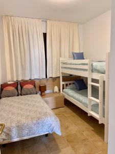 1 Schlafzimmer mit 2 Etagenbetten und einem Fenster in der Unterkunft Duquesa Village (La Casa del Loonos) in Manilva