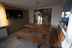 Zimmer mit 2 Bänken, einem Tisch und einem TV in der Unterkunft Das Gästehaus im Rittergut Keulrod in Bischofrod