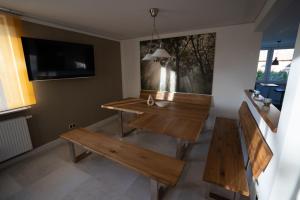 a room with two benches and a table and a tv at Ferienhaus Thüringer Wald - Garten & Terrasse in Bischofrod