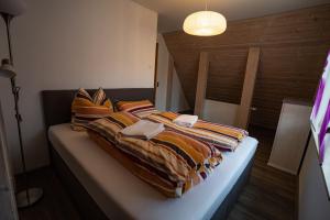 a bed with colorful blankets on it in a room at Ferienhaus Thüringer Wald - Garten & Terrasse in Bischofrod