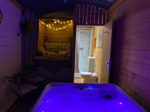 a bathroom with a purple tub in a room at Chambre avec spa privé in Candor