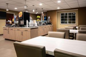 a restaurant with a counter and tables and chairs at Microtel Inn and Suites Pecos in Pecos