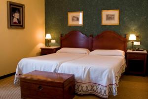 a bedroom with two beds and two tables and two lamps at Hotel Monumento Convento de San Benito in A Guarda