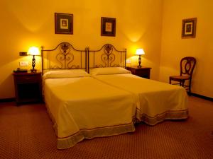 ein Schlafzimmer mit einem großen weißen Bett mit zwei Lampen in der Unterkunft Hotel Monumento Convento de San Benito in A Guarda