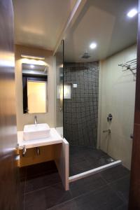 a bathroom with a sink and a shower at Hotel Spices Navi Mumbai in Ghansoli