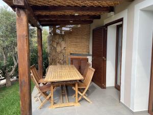 帕勞的住宿－Sardegna home luxury b&b，天井上的木桌和椅子