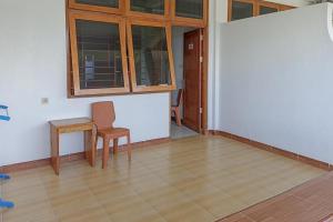Tobadi的住宿－RedDoorz Syariah at Abemoch Kampkey，一间带椅子、桌子和窗户的房间