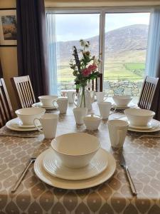 a table with plates and bowls and a vase with flowers at Gorse Hill Farm in Newcastle