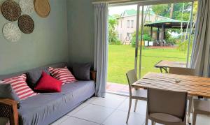 a couch in a living room with a table and a dining room at 28 and 29 The Bridge in St Lucia